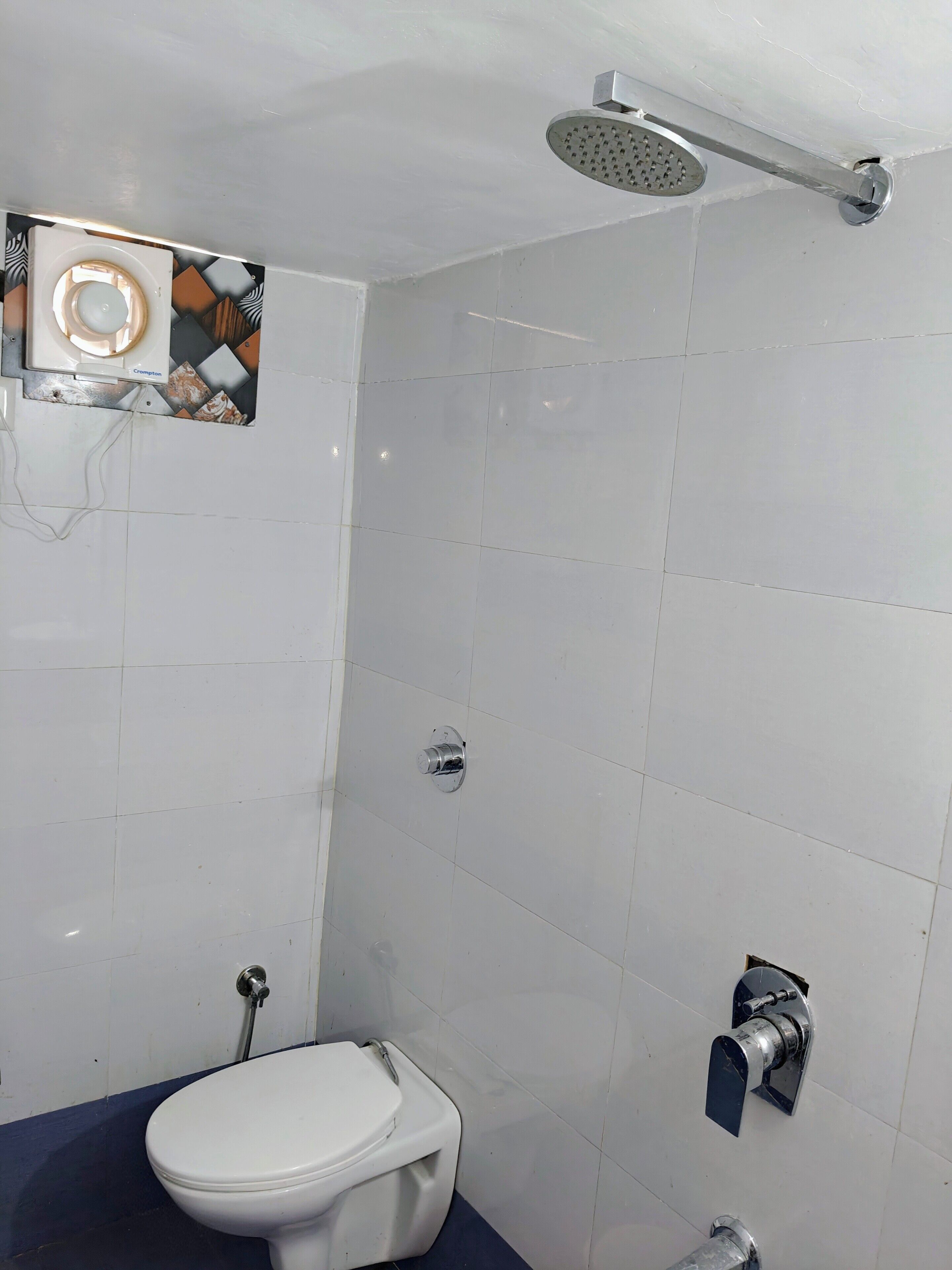 A bathroom with a toilet, a shower, and a sink.