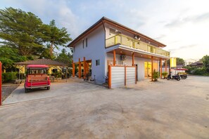 A two-story building with a garage, a covered outdoor area, and a balcony. - Tongtong Garden Holiday Hotel (Rawai)