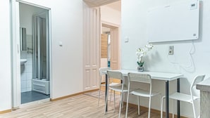 A room with a white table and chairs, a whiteboard, and a potted plant. - Comfy 2BR Apt For 6 Wiener Stadthalle (Vienna)