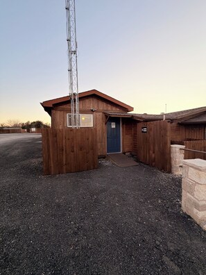 Un bâtiment en bois avec une porte bleue, une rampe et une enseigne indiquant un bureau de location.