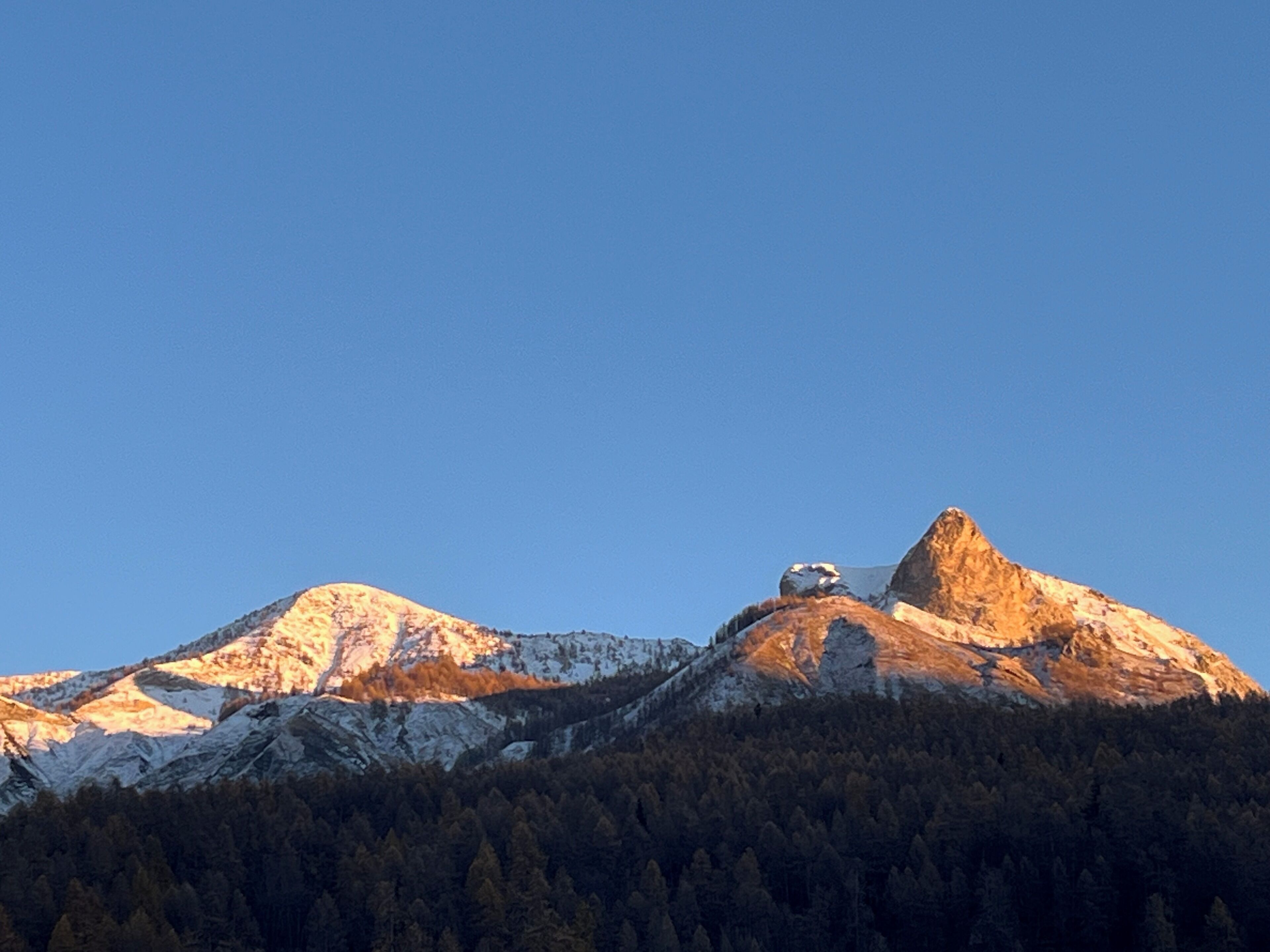 A mountain range with a prominent peak and forested slopes.