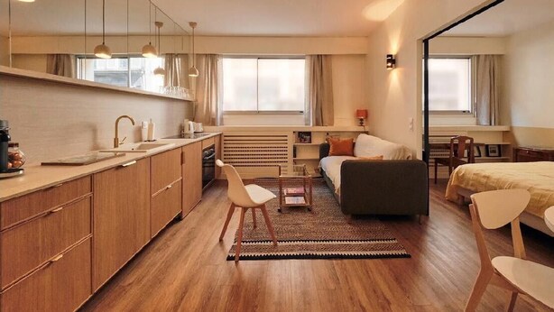 A modern, compact hotel room with a kitchenette, a sofa, a bed, and a dining area. - Elegant Apt near Eiffel Tower, Fast WiFi, (Paris)
