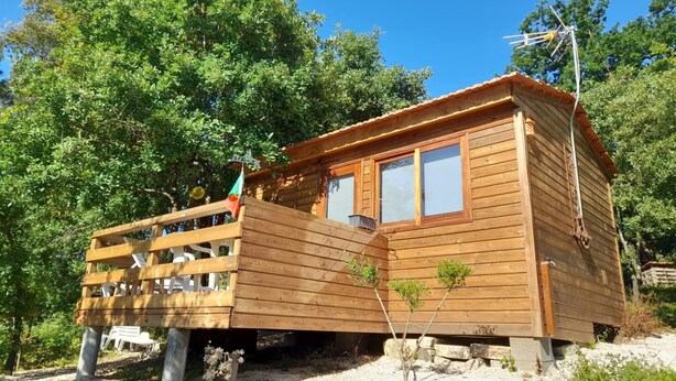 A wooden cabin with a balcony, surrounded by trees and gravel. - Acorn corner in a wooden house (Leiria)
