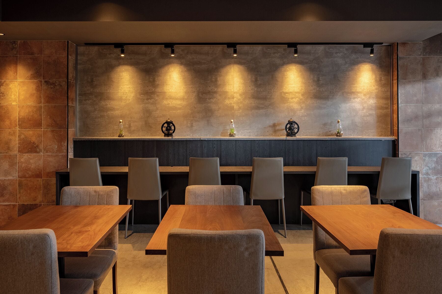 A modern dining area with a long wooden table and several upholstered chairs.