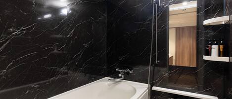A modern bathroom with a large bathtub, a glass-enclosed shower, and a vanity with a mirror.