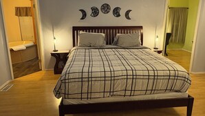 A bedroom with a bed, two bedside tables, a wall clock, and a window with curtains. - Cozy, Spacious 3BR Retreat in North Albany Family-Friendly, Near OSU & Wineries (Albany)