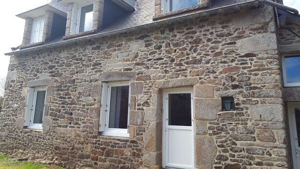 A stone building with a gabled roof, multiple windows, and a door. - Vacation house in Brittany near St Malo in fishing village (Matignon)