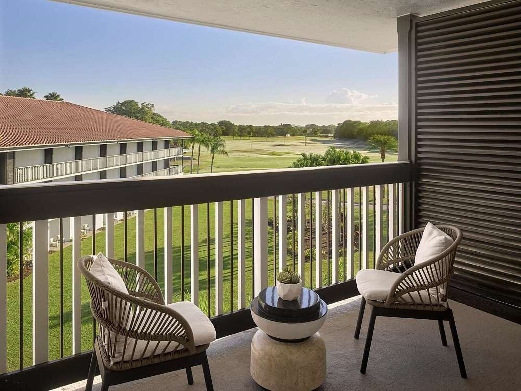 Sip morning coffee on the balcony overlooking serene greens.