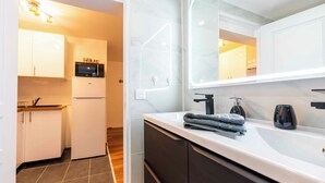 Une salle de bain moderne avec un grand miroir, un lavabo et une serviette.