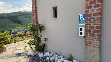 Un'area di parcheggio con un muro in mattoni, una piccola finestra e un segnale di parcheggio.