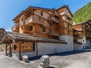 A multi-story wooden building with balconies, stone foundation, and a sign reading 'LEIGNON'. - Alpine duplex 120 m², 4 bedrooms, fireplace in Val d'Isère (Val-d'Isère)