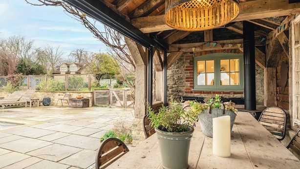 An outdoor patio with stone flooring, wooden furniture, and potted plants. - Stunning 6 BB Cottage & Annexe  (Little Milton)