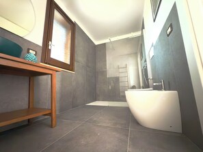 Een douche, een haardroger, een bidet, handdoeken
