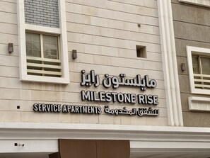 A building with a sign that reads 'MILESTONE RISE SERVICE APARTMENTS' in both Arabic and English. - Milestone Rise (Jeddah)