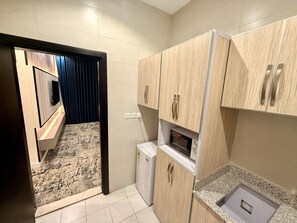 Eine kleine Küche mit Mikrowelle, kleinem Kühlschrank und Holzausstattung.