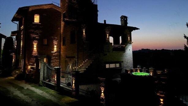 A historic building with a prominent tower and a well-lit entrance. - Il Castelletto di Gomo  (Godiasco)