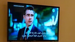 Ein an der Wand befestigtes Fernsehgerät zeigt eine Szene aus 'LONDON BOULEVARD'.