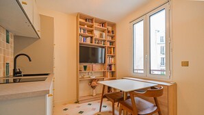 Cocina compacta con horno empotrado, lavamanos y ventana.