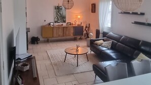 Un salon moderne avec un canapé, une table basse et un téléviseur posé sur un meuble.