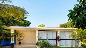 Une maison moderne dotée d’un patio couvert, d’un mur en pierre et d’une pelouse bien entretenue.