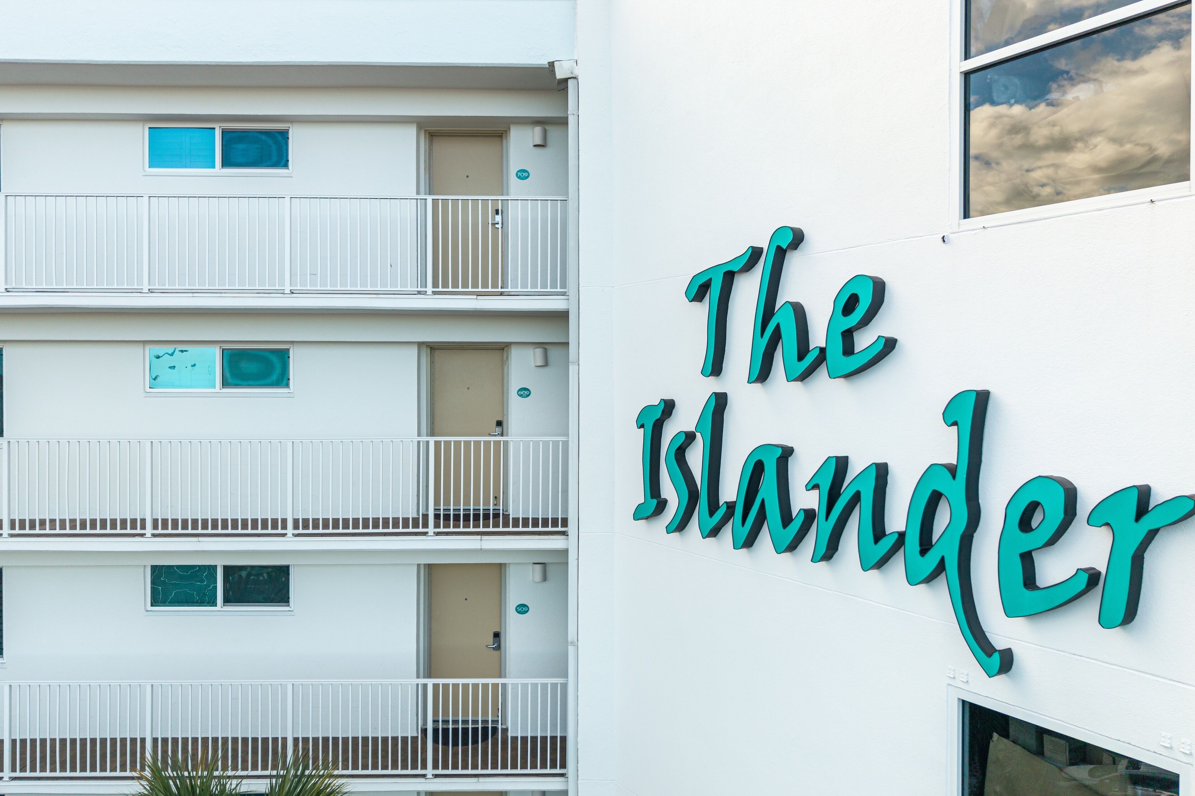 A multi-story building with balconies and a sign that reads "The Islander."