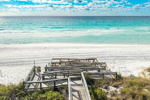 A wooden boardwalk leading to a beach with clear turquoise water and a sandy shore. - Islander 603 2 Bedroom Condo (Destin)