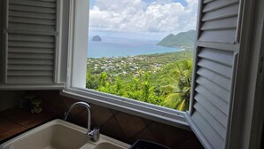 Una cocina con ventana que da a un paisaje costero.