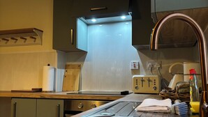 Una cocina moderna con electrodomésticos de acero inoxidable, armarios de madera y horno integrado.