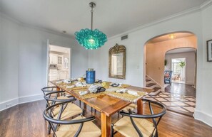 A dining area with a wooden table, woven chairs, and a decorative ceiling light. - Beautiful Historic Ringling house! (Sarasota)