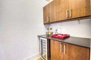 Eine Küche mit Holzausstattung, einer Arbeitsplatte und einem kleinen Kühlschrank.