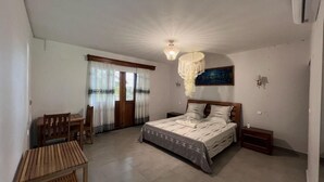 A bedroom with a bed, a desk, and a chair. - Nosy Bay View (Nosy Be)