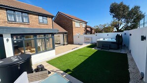 A residential backyard with a swimming pool, hot tub, and a well-maintained lawn.