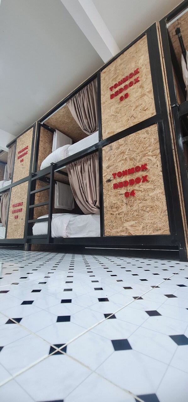 A bunk bed room with a tiled floor and wooden panels on the walls.