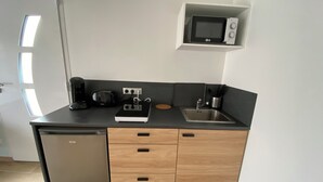 Eine kompakte Küche mit Geschirrspüler, Mikrowelle, Toaster und Spüle.
