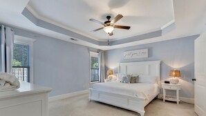 A bedroom with a white bed, a ceiling fan, and a window with blinds. - Salt Air Cottage - Private Pool, Dog Friendly, 4 Blocks to Beach (Carolina Beach)