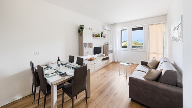 Un salon moderne comprenant un coin repas, un canapé et un téléviseur.