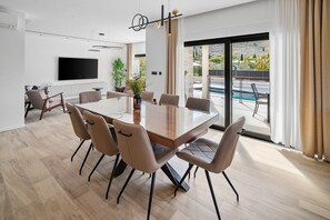 Enjoy shared family breakfasts at this grand wooden dining table with direct access to the outdoor terrace. - Stylish 4-Bedroom Villa Agrosa with 30 m2 Private Pool, Hydromassage, Finnish Sauna and Fun zone (Srinjine)