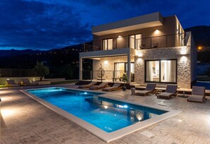 A modern two-story house with a swimming pool, outdoor seating, and a stone facade. - Stylish 4-Bedroom Villa Agrosa with 30 m2 Private Pool, Hydromassage, Finnish Sauna and Fun zone (Srinjine)