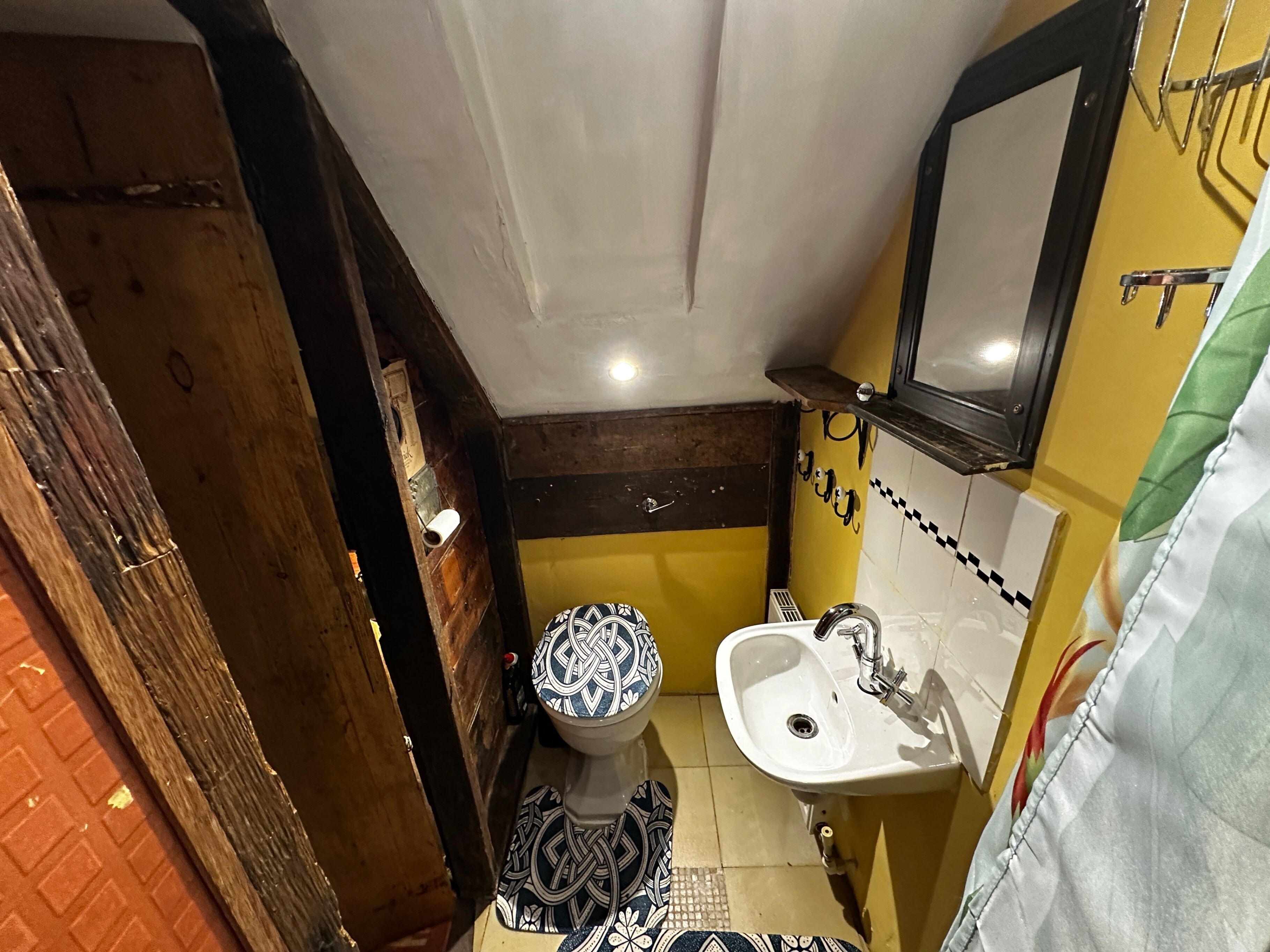 A small bathroom with a toilet, sink, and mirror.