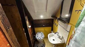 A small bathroom with a toilet, sink, and mirror.