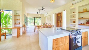 Una cocina amplia con una isla grande, armarios de madera y una estufa integrada.