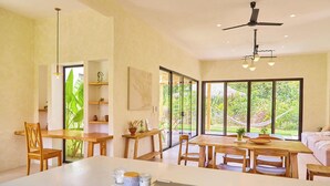 Una habitación amplia con un gran comedor, sillas de madera y un ventilador de techo.