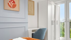 A hotel room with a bed, a desk, a wardrobe, and a balcony with a view. - Modern Luxury 4Bdrm Duplex | Business/Vacay | 15min to LDN centre | Free Parking (London)