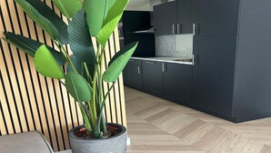 A modern kitchen with dark cabinets, a marble countertop, and a potted plant. - Holiday Home by Palette Resort De-steppe (Ulicoten)