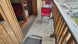 Un balcone con vista su un cantiere edile e edifici sullo sfondo.