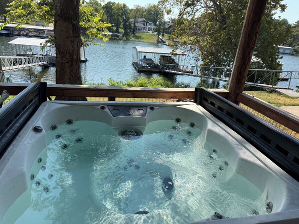 A hot tub with a view of a lake and docked boats. - Lakefront A-frame cabin with Dock access (Afton)