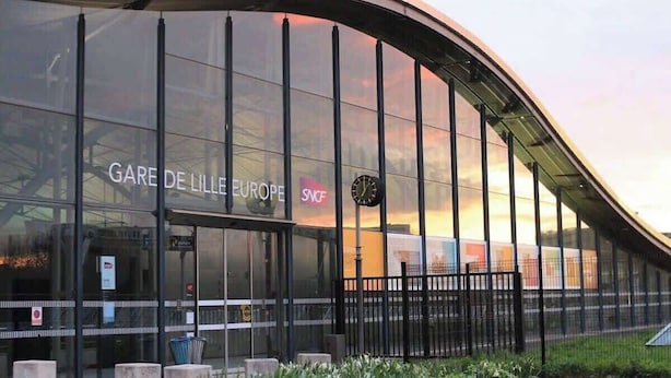 A modern building with large glass windows and a curved roof.