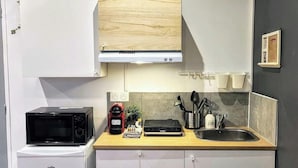 A compact kitchen with a microwave, toaster, and sink.