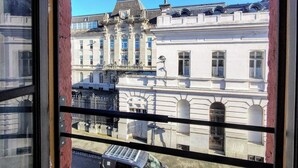 Vista de un edificio de arquitectura clásica, que incluye un balcón y una estatua.