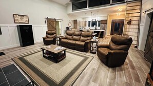 A spacious living room with a high ceiling, a dining area, and a kitchen. - Finger Lake Retreat (Prattsburgh)